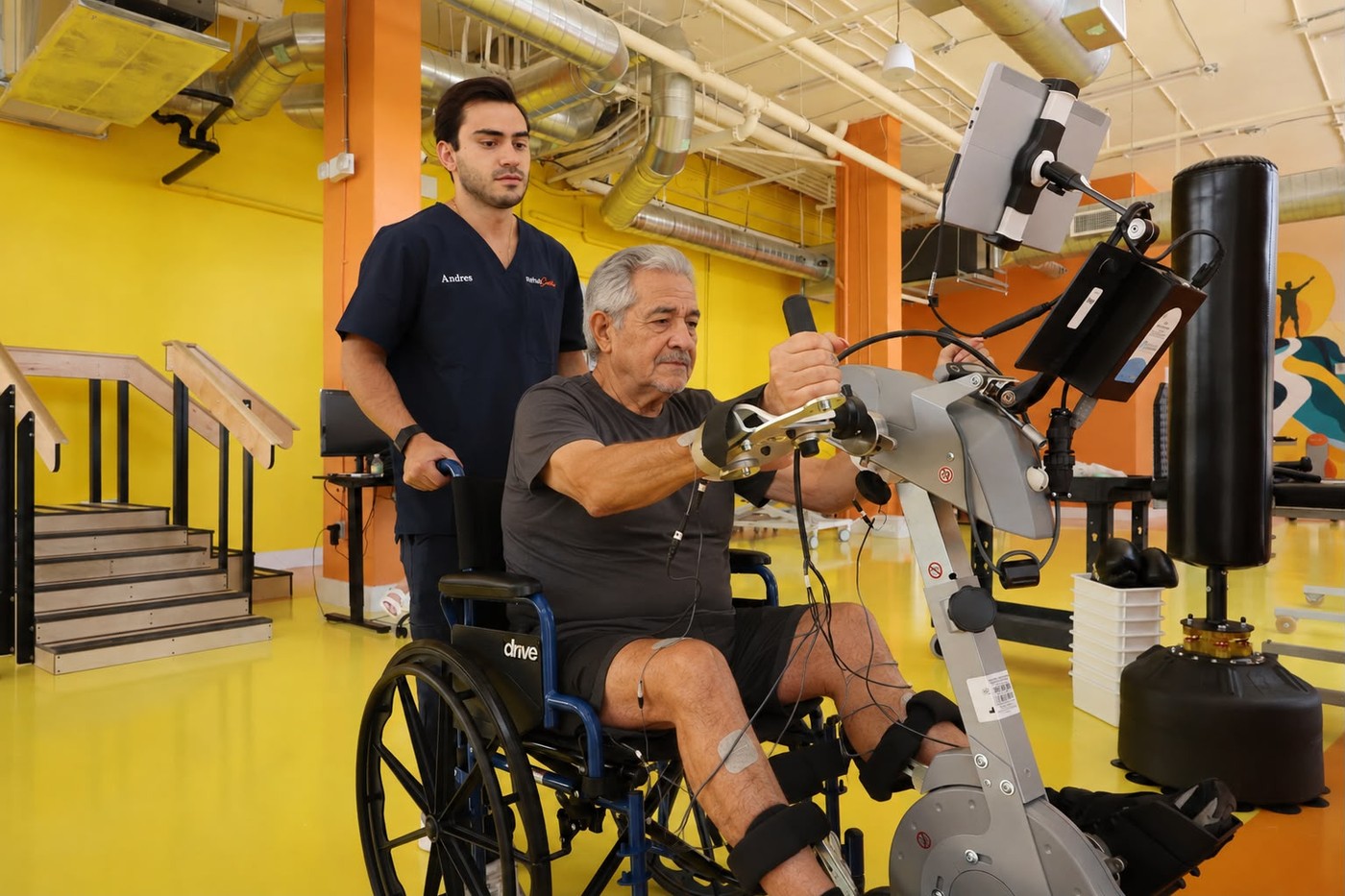 Patient using FES cycling with clinical support at RehabCenter